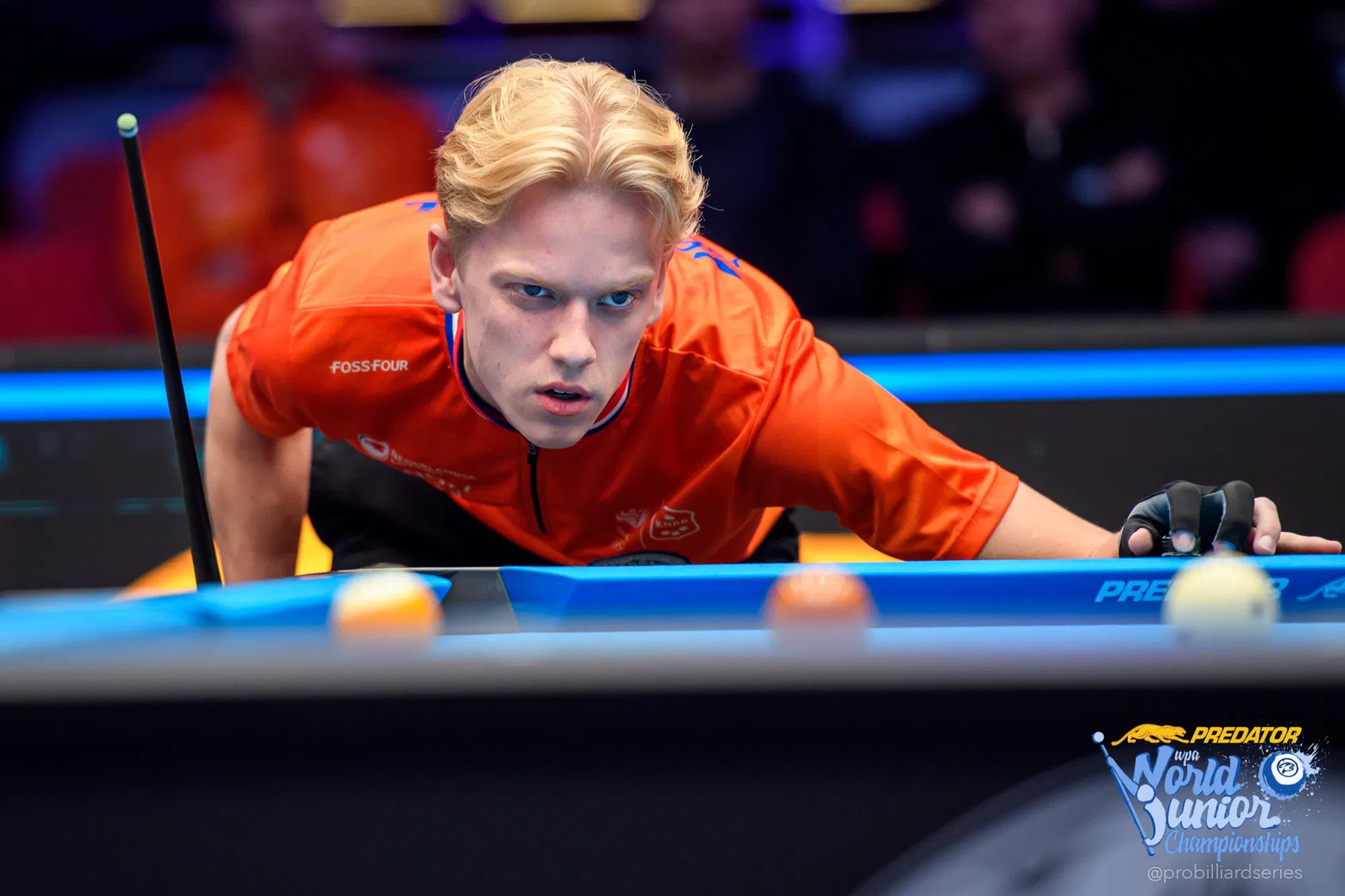 Yannick Pongers lines up a shot in a bright orange TeamNL jersey